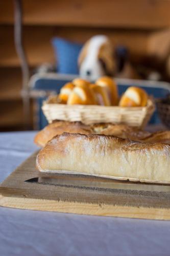 une table avec deux paniers de pain et un chien dans l'établissement Le Chalet d'Eléonore, aux Saisies