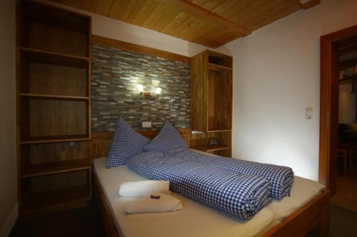 a bedroom with a bed with blue and white sheets at Ferienhaus Panorama in Biberwier
