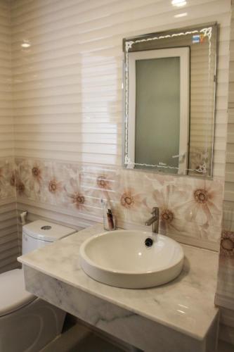 a bathroom with a sink and a toilet and a mirror at Phuong Binh House in Phú Quốc