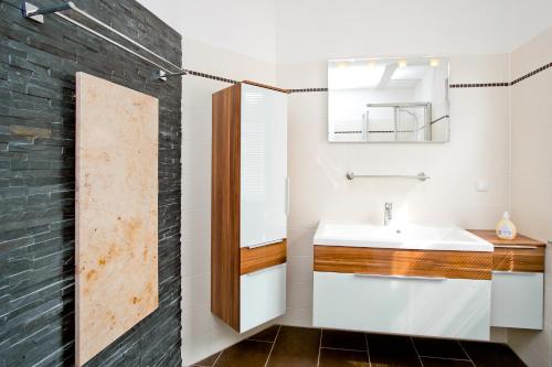 ein Badezimmer mit Waschbecken und Spiegel in der Unterkunft Ferienwohnungen Ostrea & Rugia in Breege