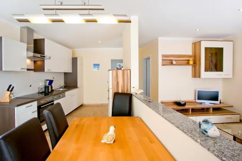 eine Küche und ein Esszimmer mit einem Holztisch in einem Zimmer in der Unterkunft Ferienwohnungen Ostrea & Rugia in Breege