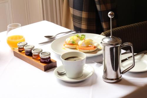 - une table avec une assiette de nourriture et une tasse de café dans l'établissement The Falcon Hotel, à Uppingham
