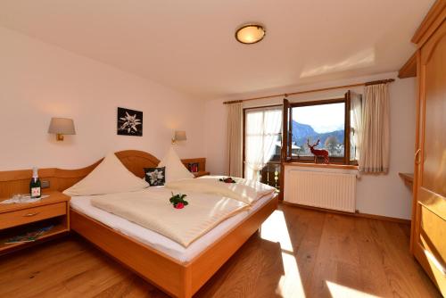 een slaapkamer met een bed en een groot raam bij Ferienwohnungen Thannheimer in Oberstdorf