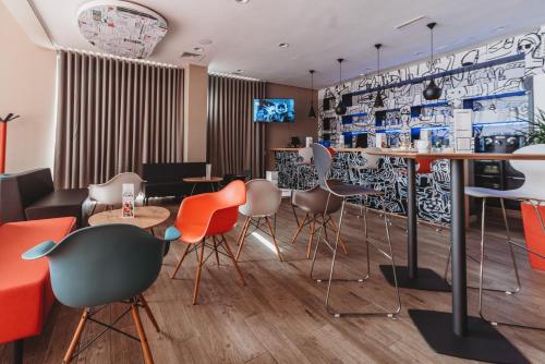 un restaurante con un bar con sillas y mesas en Ibis Mohammedia, en Mohammedia