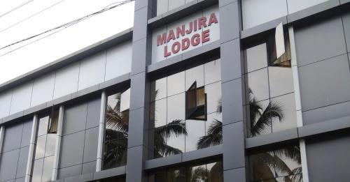 a building with a marawi lodge sign on it at Manjira Lodge in Guruvāyūr