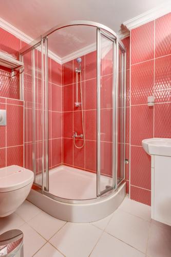 a bathroom with a shower and a toilet and a sink at Nefes Hotel in Ayvalık