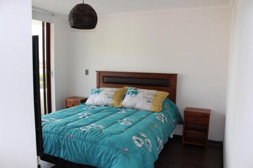 1 dormitorio con 1 cama con edredón verde en Departamentos Parts Concepción, en Concepción