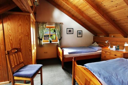 a bedroom with two beds and a chair at BioDohrn in Bad Zwischenahn