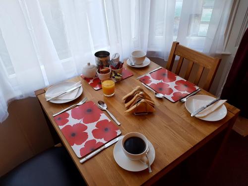 a wooden table with food and drinks on it at Fosters Guest House in Weymouth