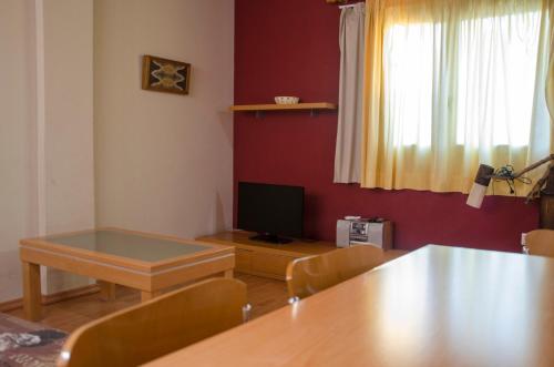 a living room with a table and a television at Apartaments El Jaç in Montblanc