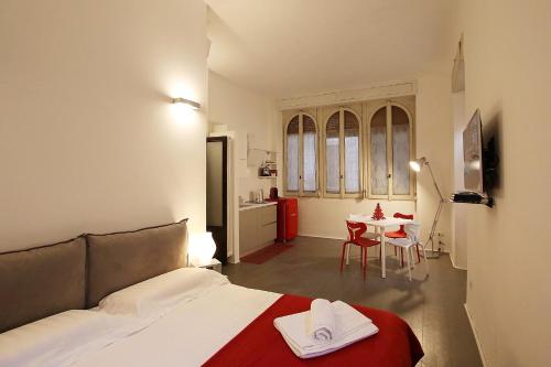 ミラノにあるSAHI - Residenza Bianca di Savoiaのベッドルーム1室(ベッド1台、テーブル、椅子付)