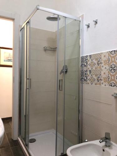 W łazience znajduje się szklana kabina prysznicowa i umywalka. w obiekcie Casa Di TaTa w mieście Trezzo sullʼAdda