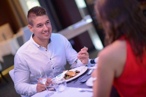 a man sitting at a table with a plate of food at Aura Hotel Adults Only in Balatonfüred