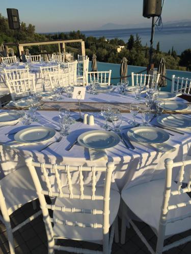 a table set up for a wedding with white chairs at Elimnion Resort in Khronia