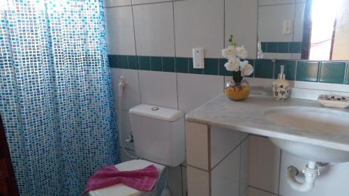 a bathroom with a toilet and a sink at Vila Beija-flor in Canoa Quebrada
