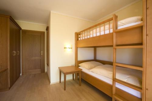 a bedroom with two bunk beds and a table at Garten - Hotel Sallerhof in Salzburg