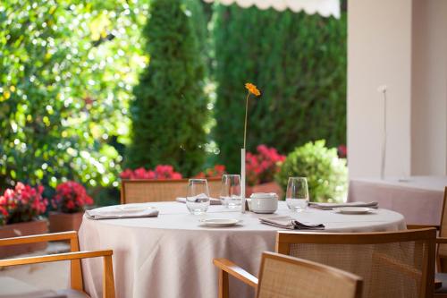 un tavolo con bicchieri da vino e un fiore sopra di Hotel Emporda a Figueres