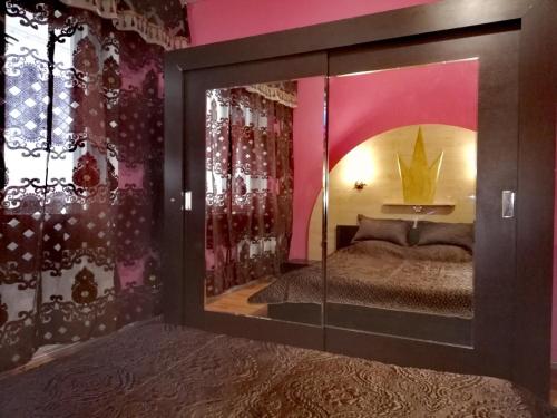 イヴァノヴォにあるApartments on Moskovskiy 12のベッドルーム1室(鏡、ピンクの壁のベッド1台付)
