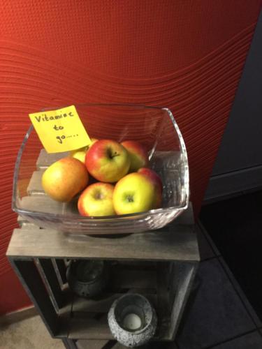 a bowl of apples and other fruit on a shelf at Hotel Zum Alten Schlagbaum in Wegberg