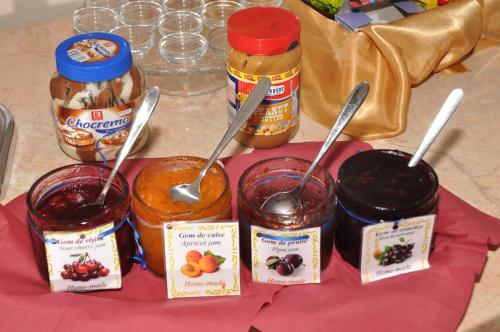 a group of four jars of jam with spoons in them at Hotel Bulevard Prestige in Slatina