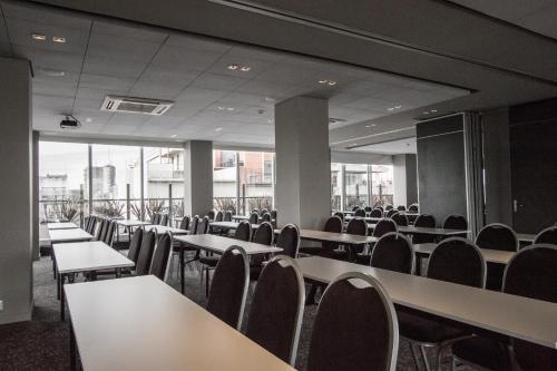 an empty room with tables and chairs and windows at CasaSur Palermo Hotel in Buenos Aires