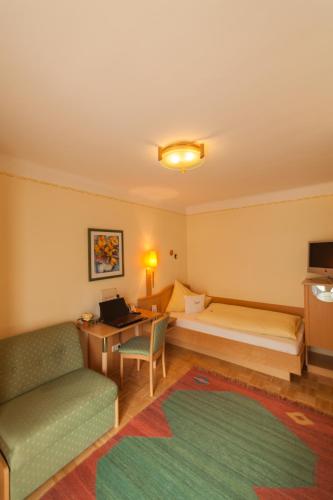 a hotel room with a bed and a desk at Garten - Hotel Sallerhof in Salzburg