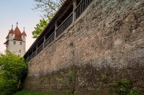 a building on the side of a wall next to a mountain at Old Town Apartments in Kaufbeuren