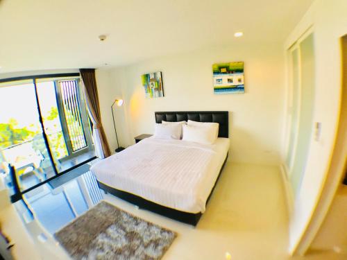 a bedroom with a bed and a large window at Seaview At Cape Panwa in Panwa Beach