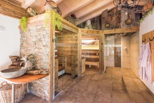 a rustic bathroom with a stone wall and a sink at Almdorf Tirol in Haldensee