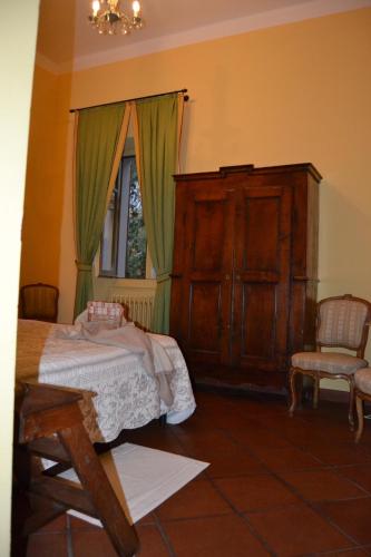 a bedroom with a bed and a chair and a window at Albergo Residence Perosi in Tortona
