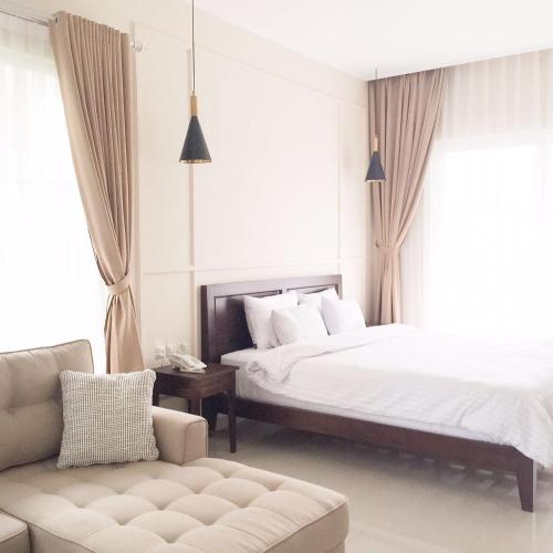 a hotel room with two beds and a couch at Sevilla Resort Magelang in Magelang
