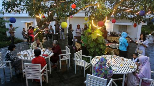 a group of people sitting around tables at a party at Sevilla Resort Magelang in Magelang