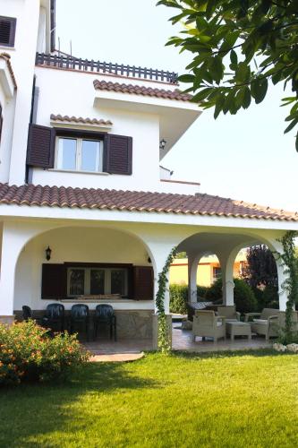a large white house with a patio with tables and chairs at Domus Dams B&B in Montescaglioso