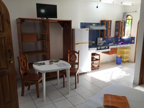 a kitchen with a table and chairs and a refrigerator at La Perlita in Jacó