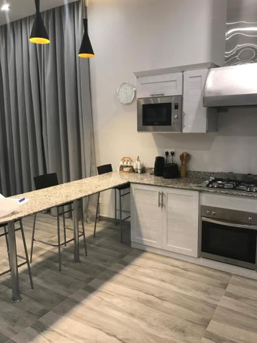 a kitchen with white cabinets and a table with chairs at Sama Chalet kuwait in Al Khīrān