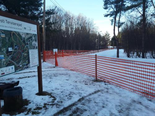 a sign in the snow next to a fence at VBE apartments in Narva