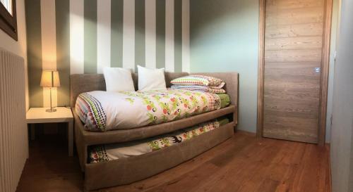 a bed with pillows on it in a room at Elegante attico sulle piste di Pila in Pila