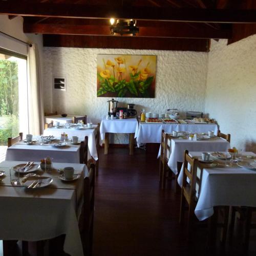 a dining room with white tables and chairs at Casa Calfu in Santa Cruz