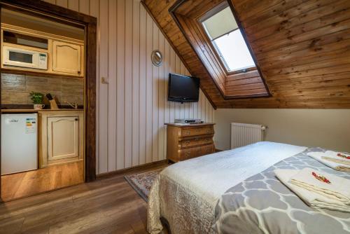 a bedroom with a bed and a tv and a kitchen at Vila House Family in Poprad