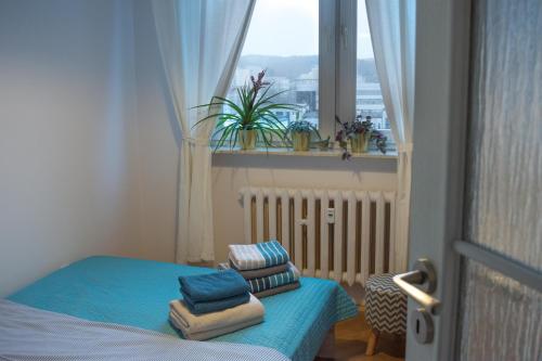 mały pokój z oknem i łóżkiem z niebieską pościelą w obiekcie Apartament Widokówka w mieście Gdynia