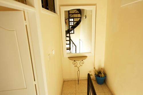 a hallway with a mirror and a stair case at Pissouri Village Studios in Pissouri