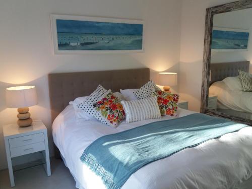 a bedroom with a bed with pillows and a mirror at Rinconada del Mar in Punta del Este