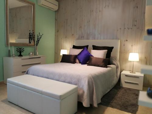 a bedroom with a large bed with purple pillows at Ses Roques in Alcudia