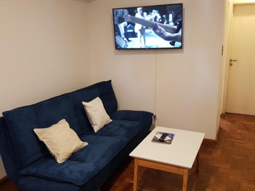 sala de estar con sofá azul y mesa en Apartamento Carlucci en Córdoba
