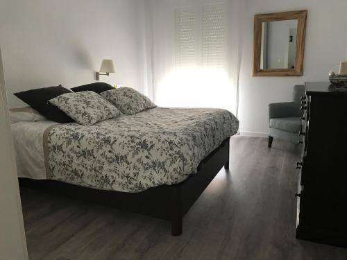 1 dormitorio con cama, ventana y silla en Apartamento Larrabide, en Pamplona