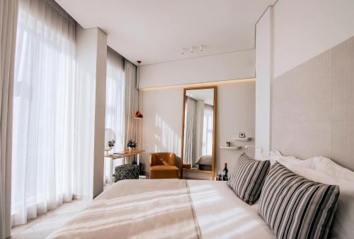 a bedroom with a large bed and a mirror at 65 Hotel, Rothschild Tel Aviv - an Atlas Boutique Hotel in Tel Aviv