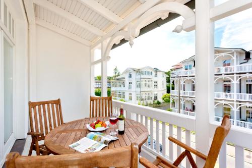 a porch with a wooden table and chairs on a balcony at Hotel Villa Belvedere in Binz