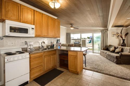 a kitchen with a white stove top oven next to a couch at Beachwood Condos & Resort in Copalis Beach