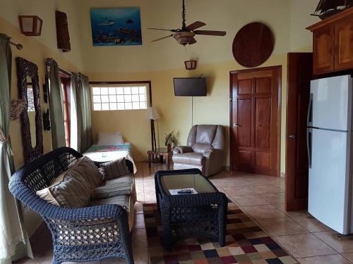 a living room with a couch and a refrigerator at Alan's Paradise Hotel in Placencia Village