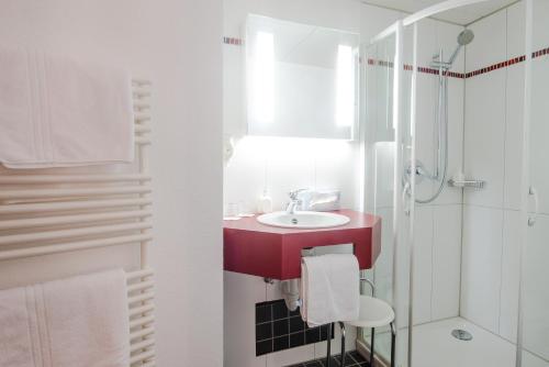 een badkamer met een rode wastafel en een douche bij Hotel Gasthof zum Rössle in Altenstadt